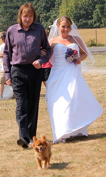 Bruno, escorting bride down the aisle at backyard wedding